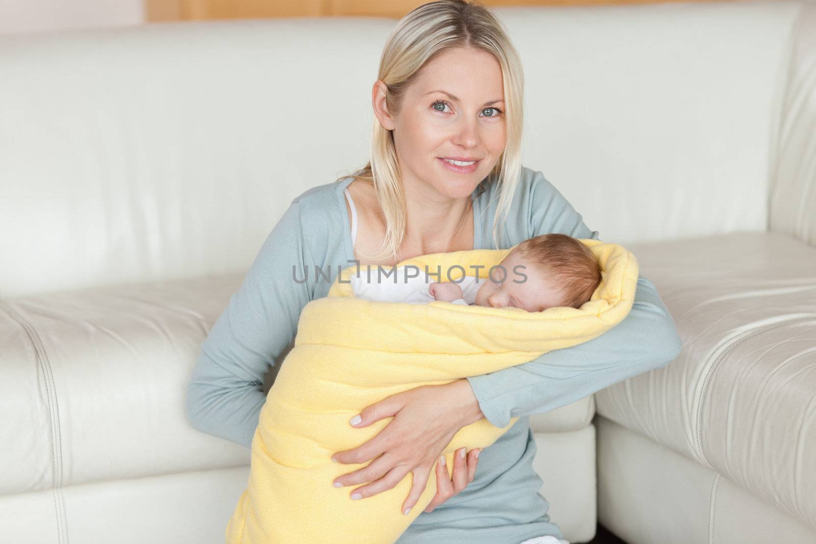 Young mother sitting on the floor with her baby in her arms