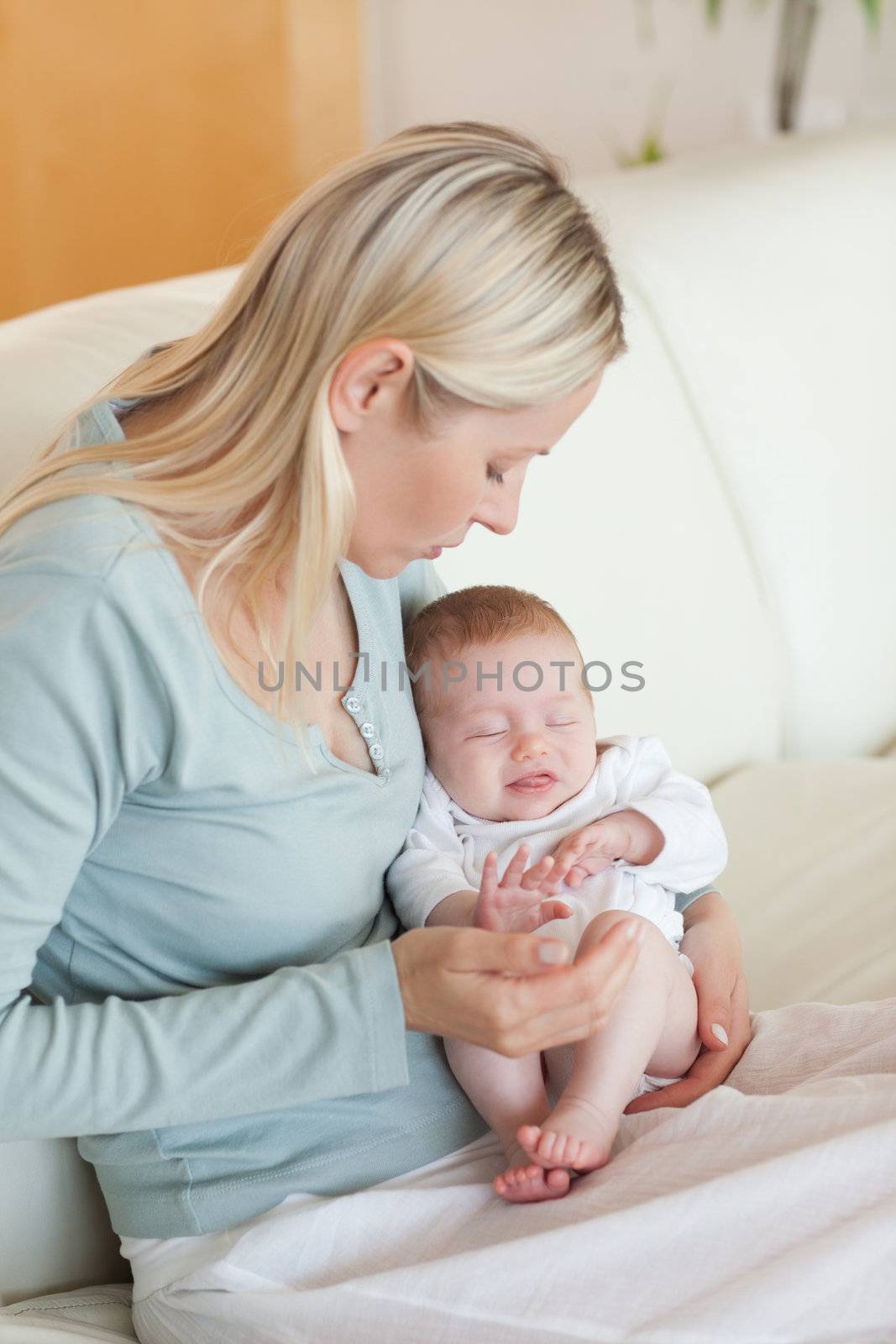 Young mother on the sofa with her baby on her lap
