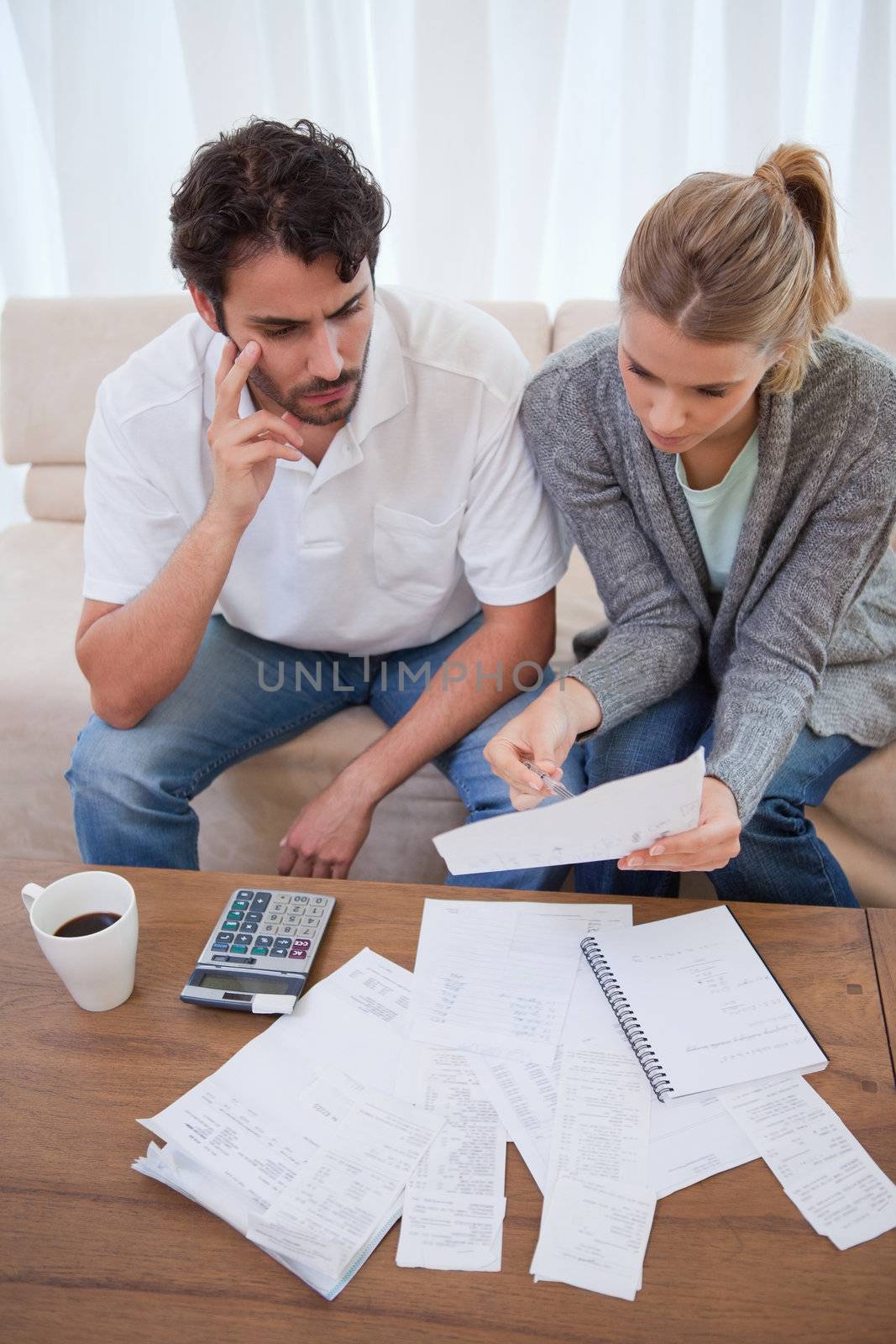 Portrait of a worried young couple doing their accounting in their living room