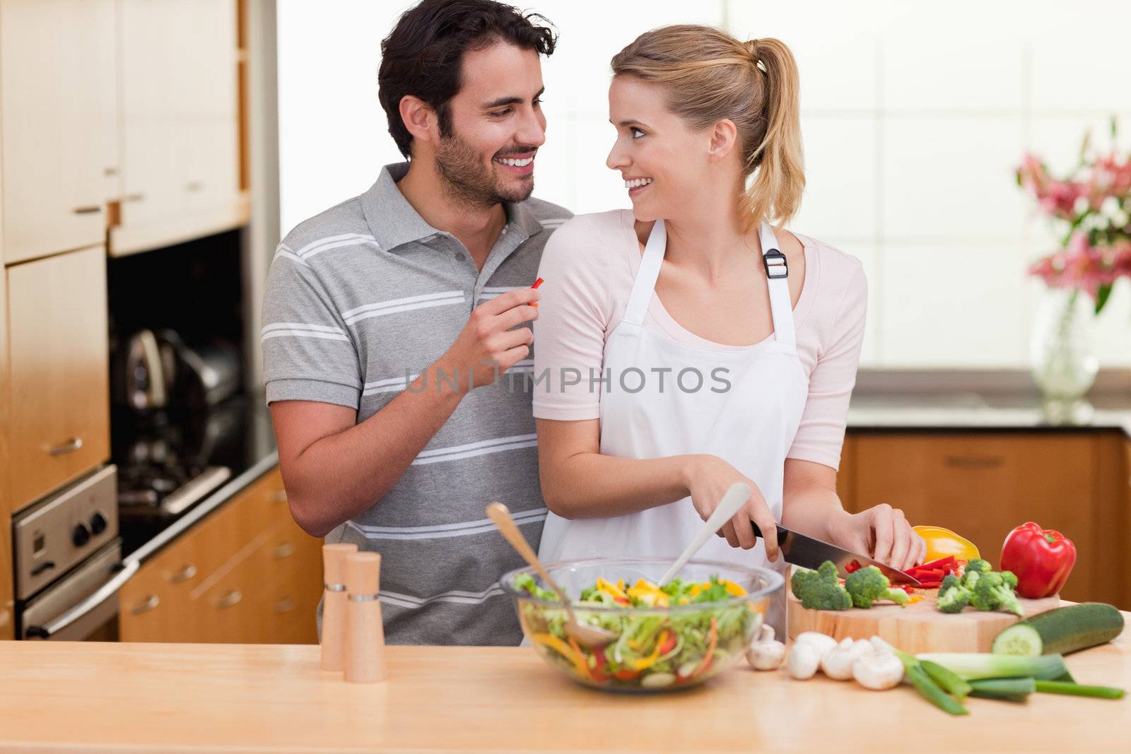 Young couple slicing vegetables in their living room