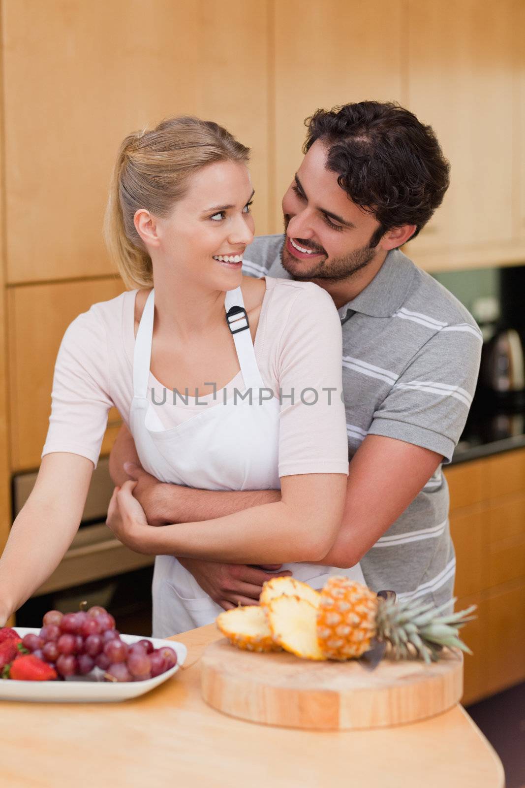 Portrait of a couple eating fruits in their kitchen