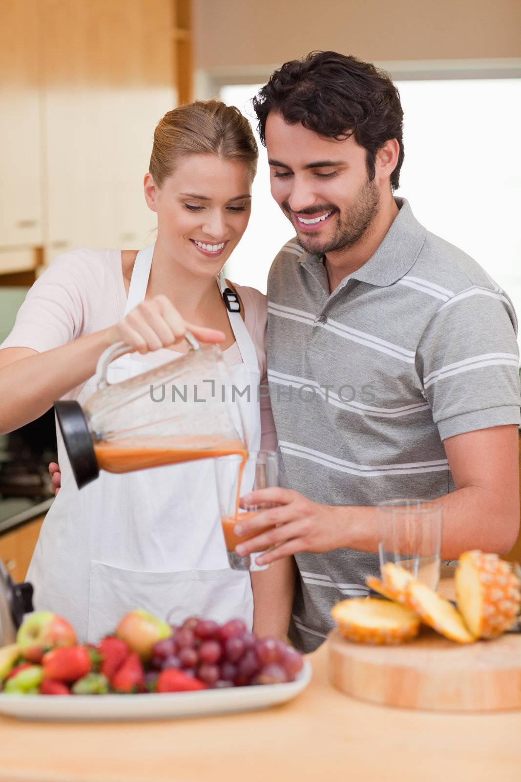 Portrait of a young couple drinking fruits juice in their kitchen