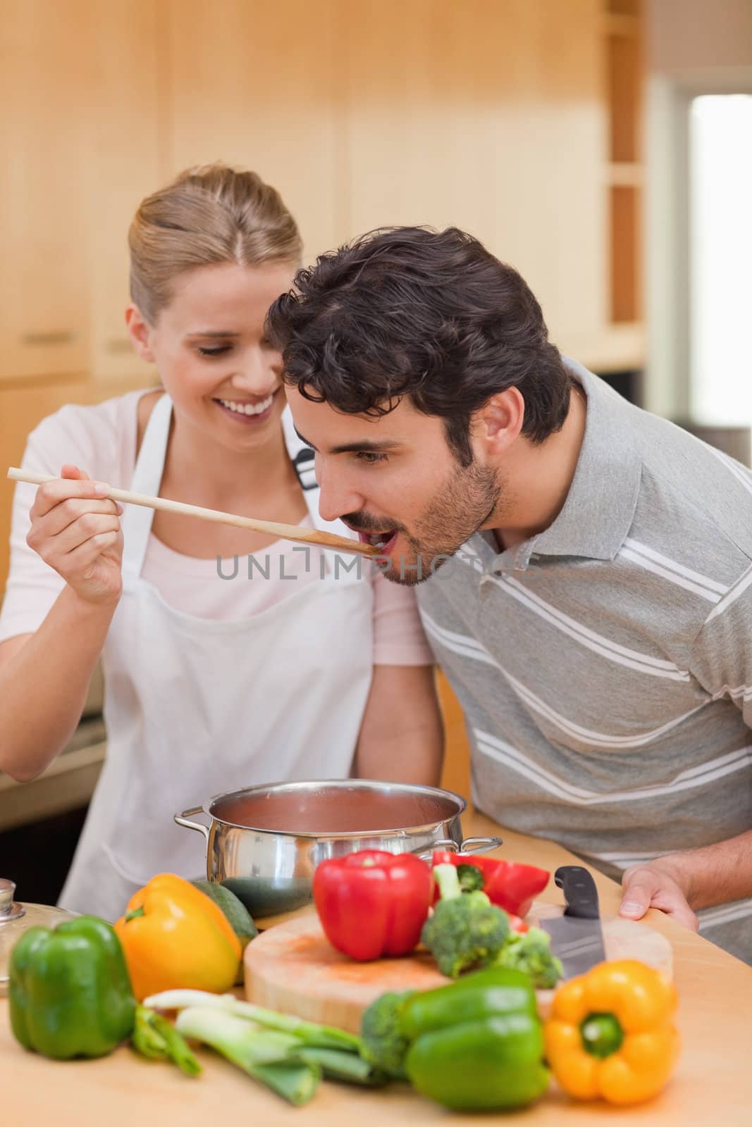 Portrait of a young couple preparing a sauce in their kitchen