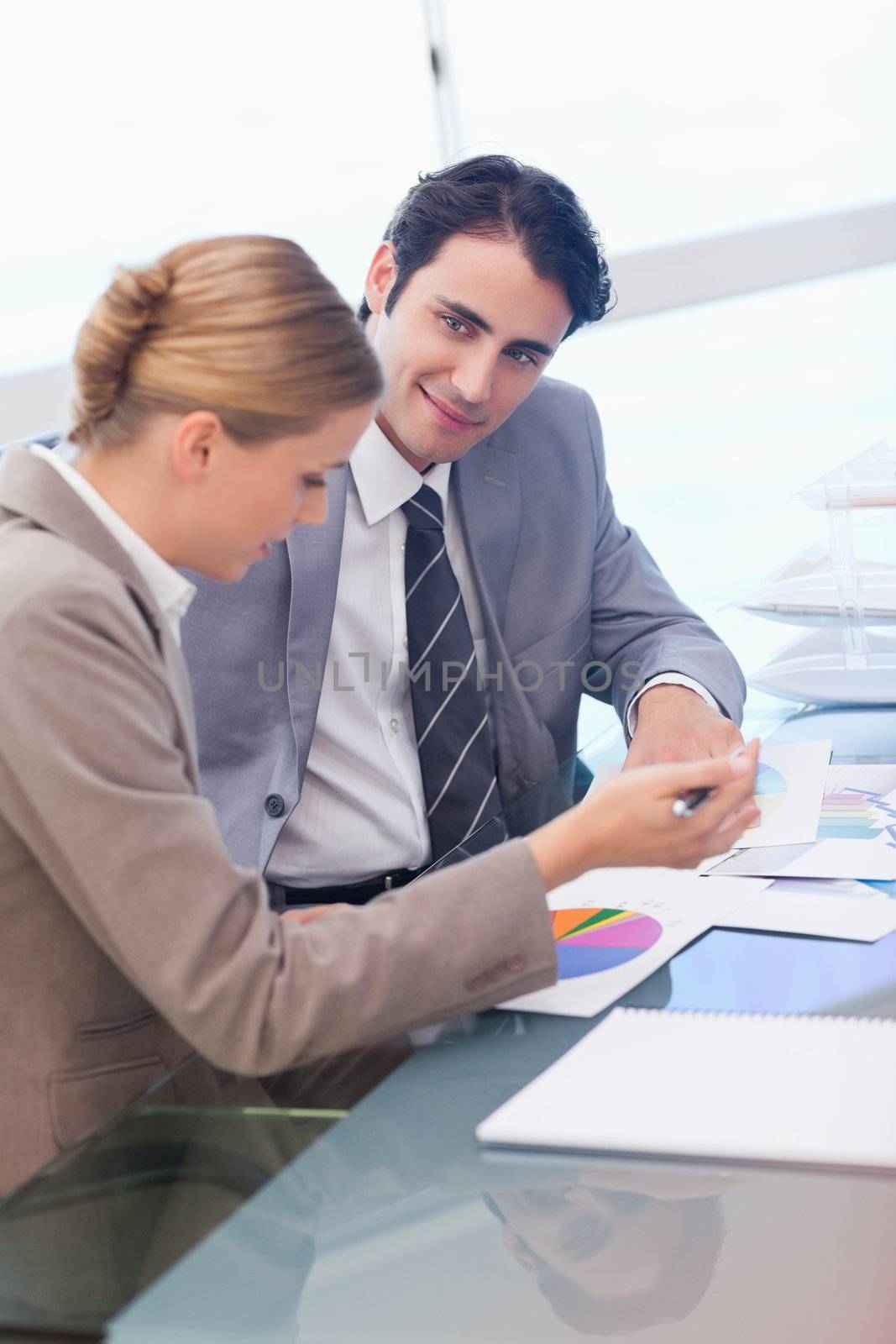 Portrait of business people looking at statistics in a meeting room