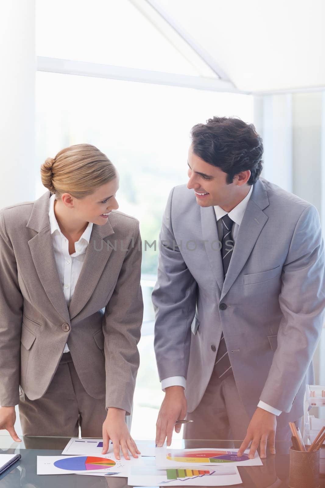 Portrait of happy business people looking at statistics in a meeting room