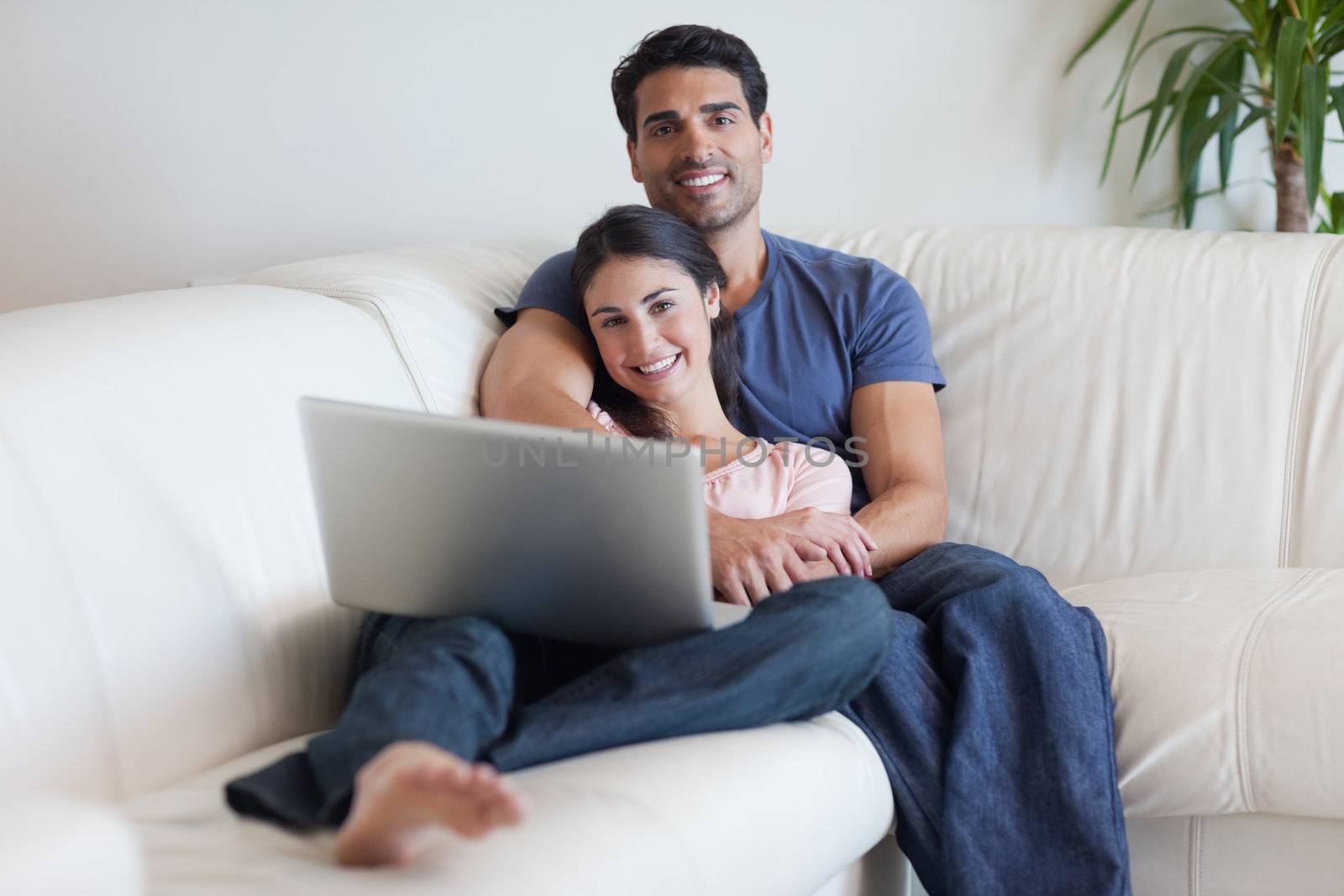Couple watching a movie with a laptop in their living room
