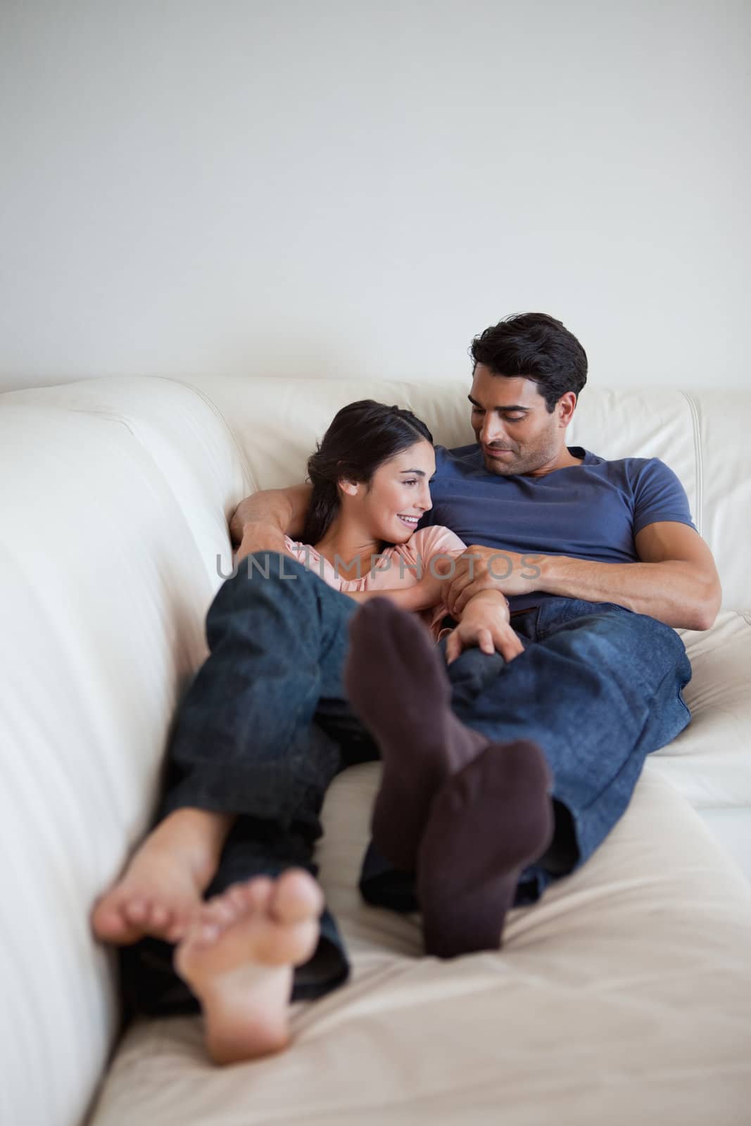 Portrait of a couple lying on a couch looking away from the camera