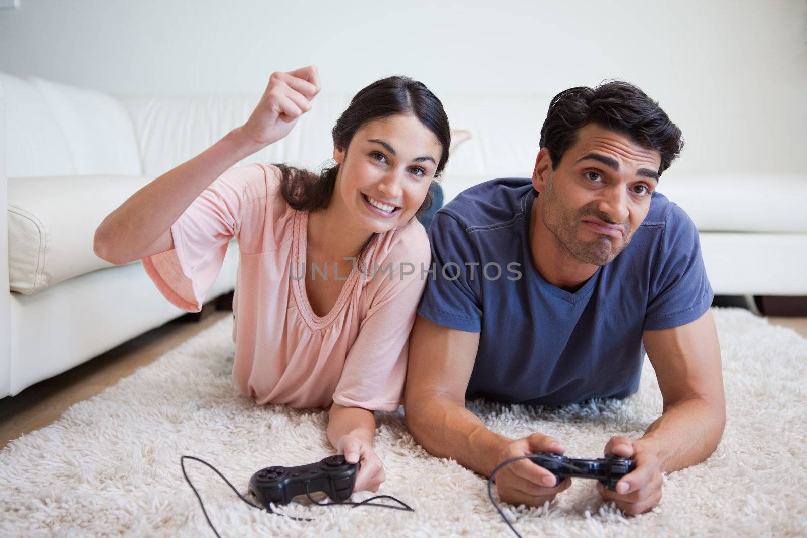 Woman beating her boyfriend while playing video games in their living room