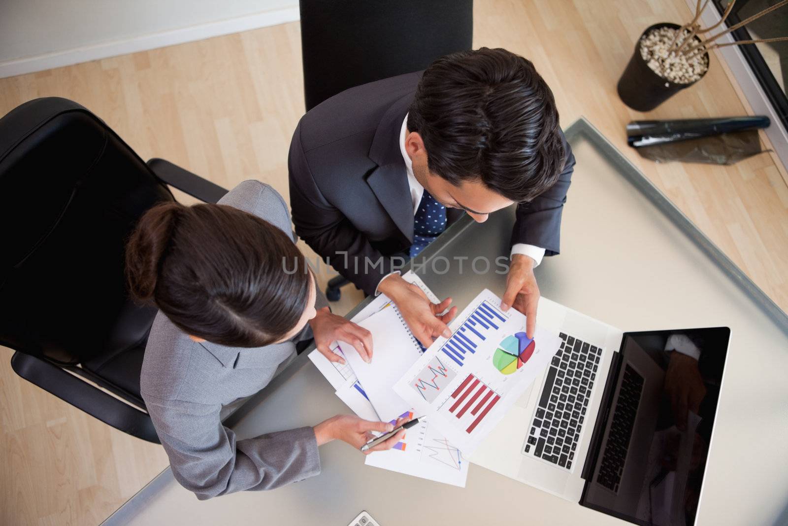 Young sales persons studying statistics in an office