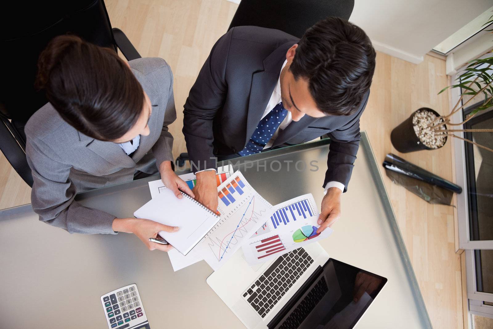 Focused sales persons studying statistics in an office