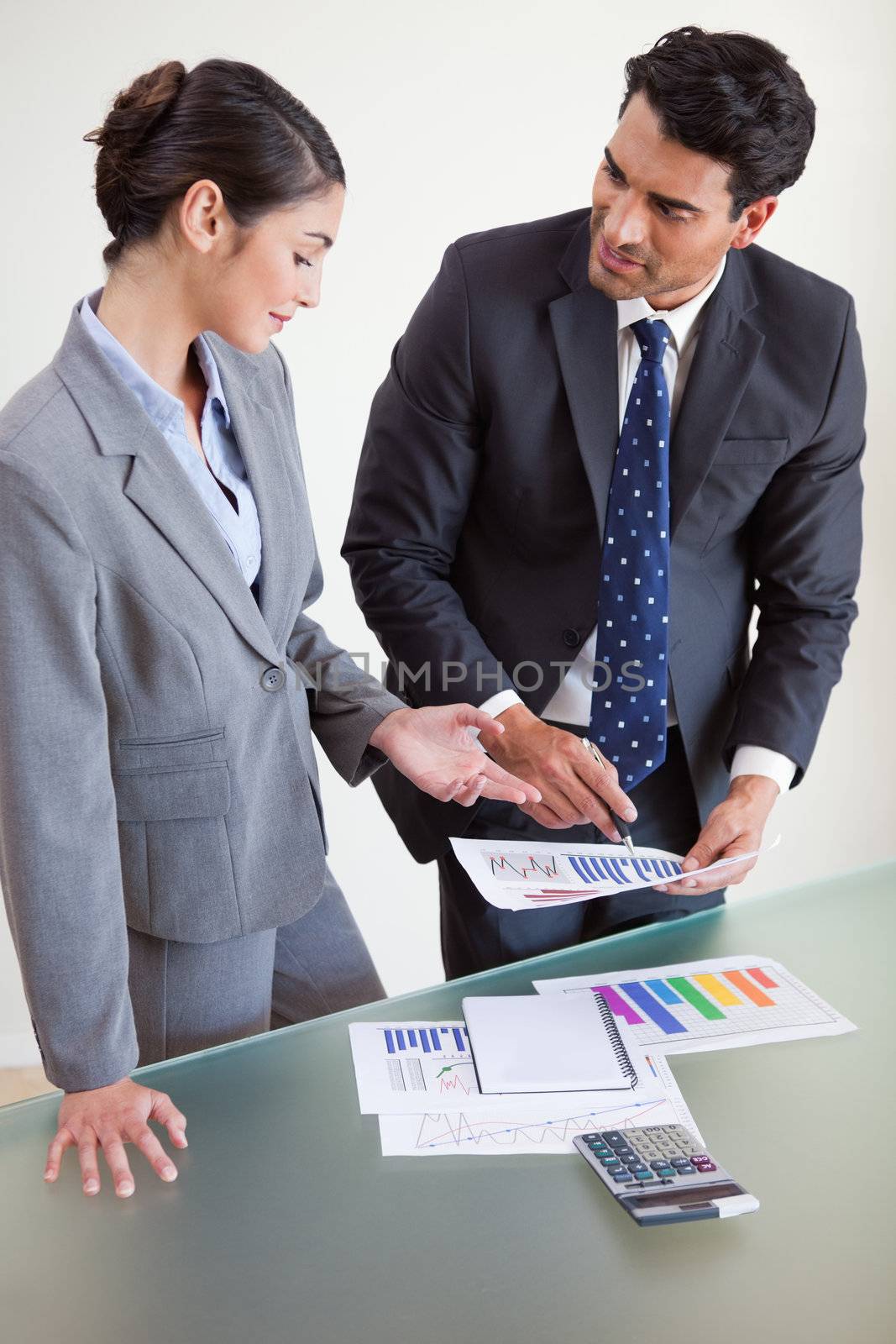 Portrait of sales persons studying their results in an office