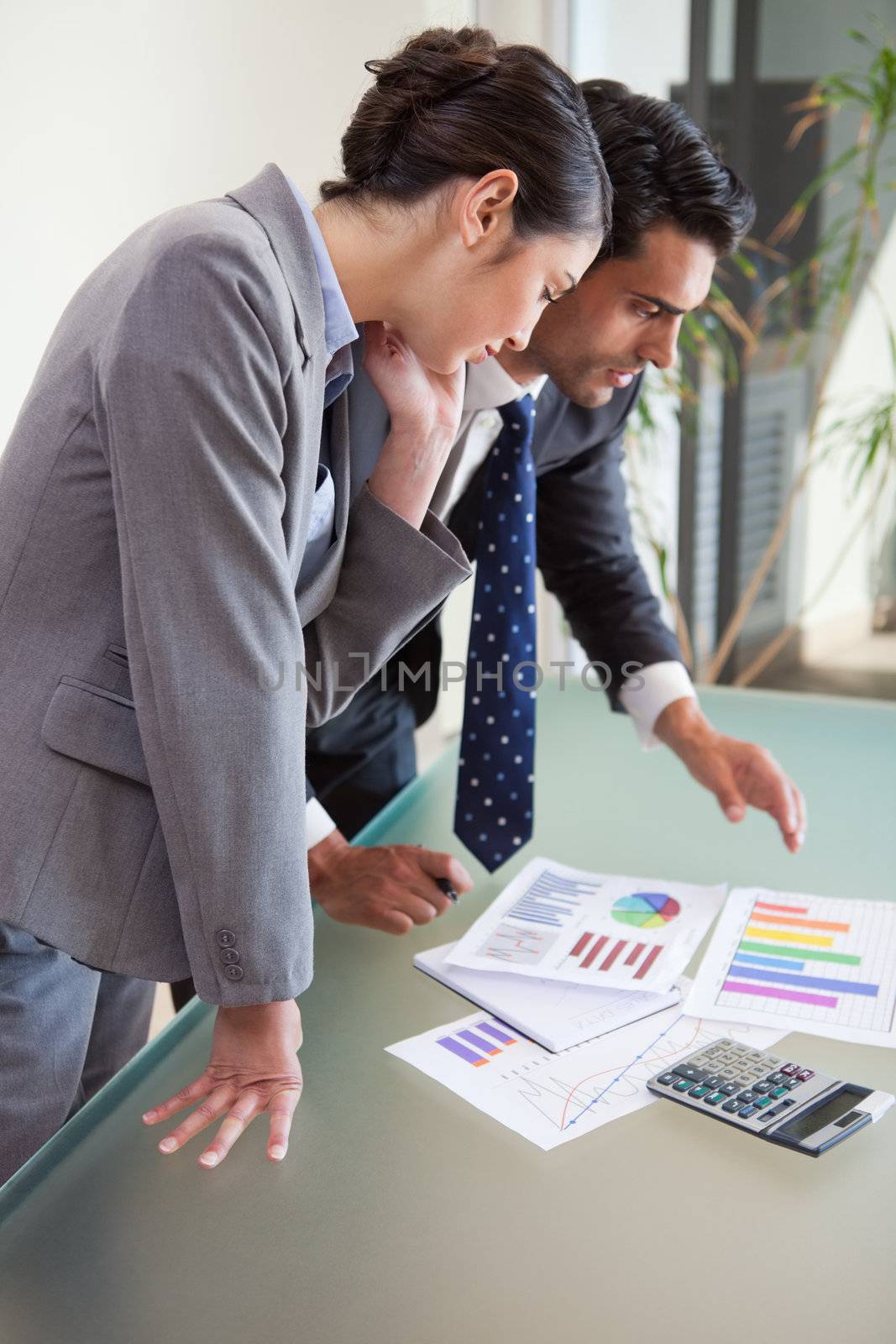 Portrait of young sales persons studying their results in an office