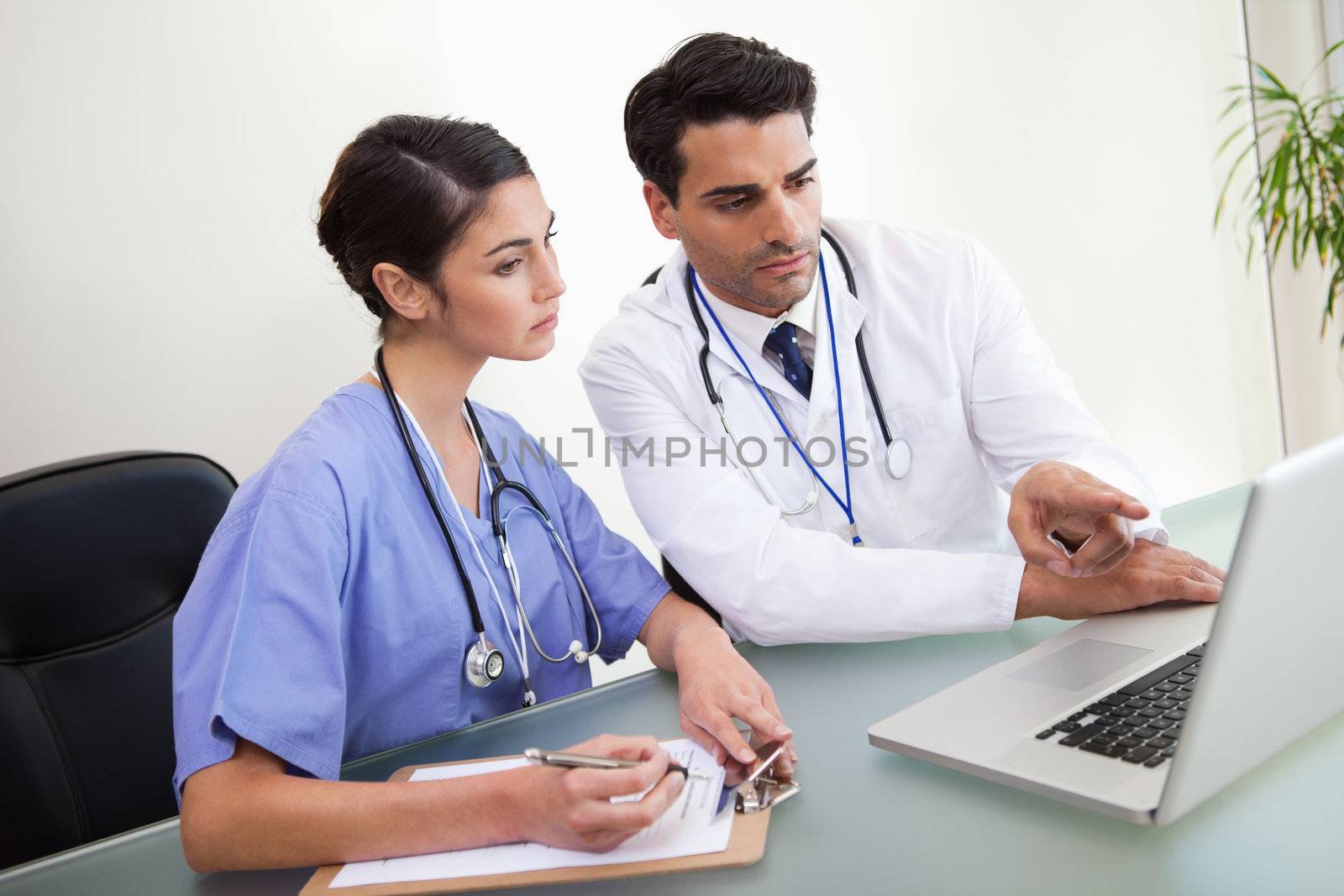 Doctors working with a notebook in an office