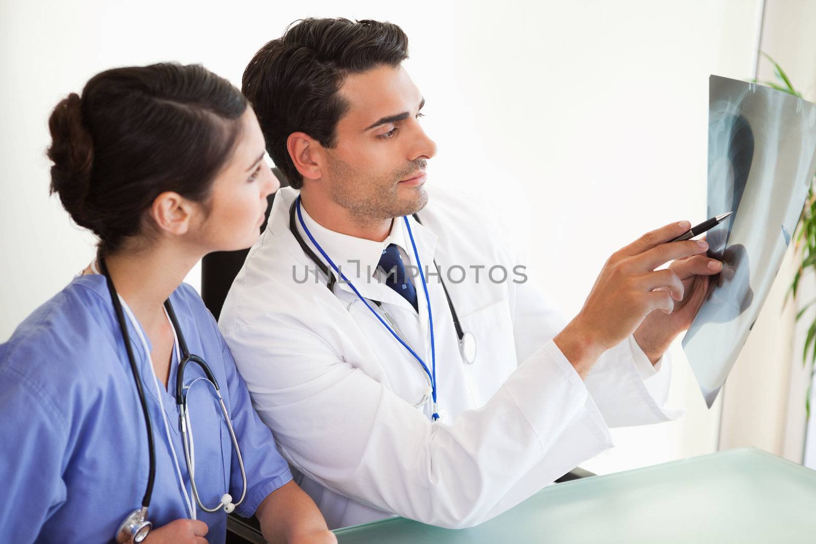 Young doctors looking at a set of X-ray in an office