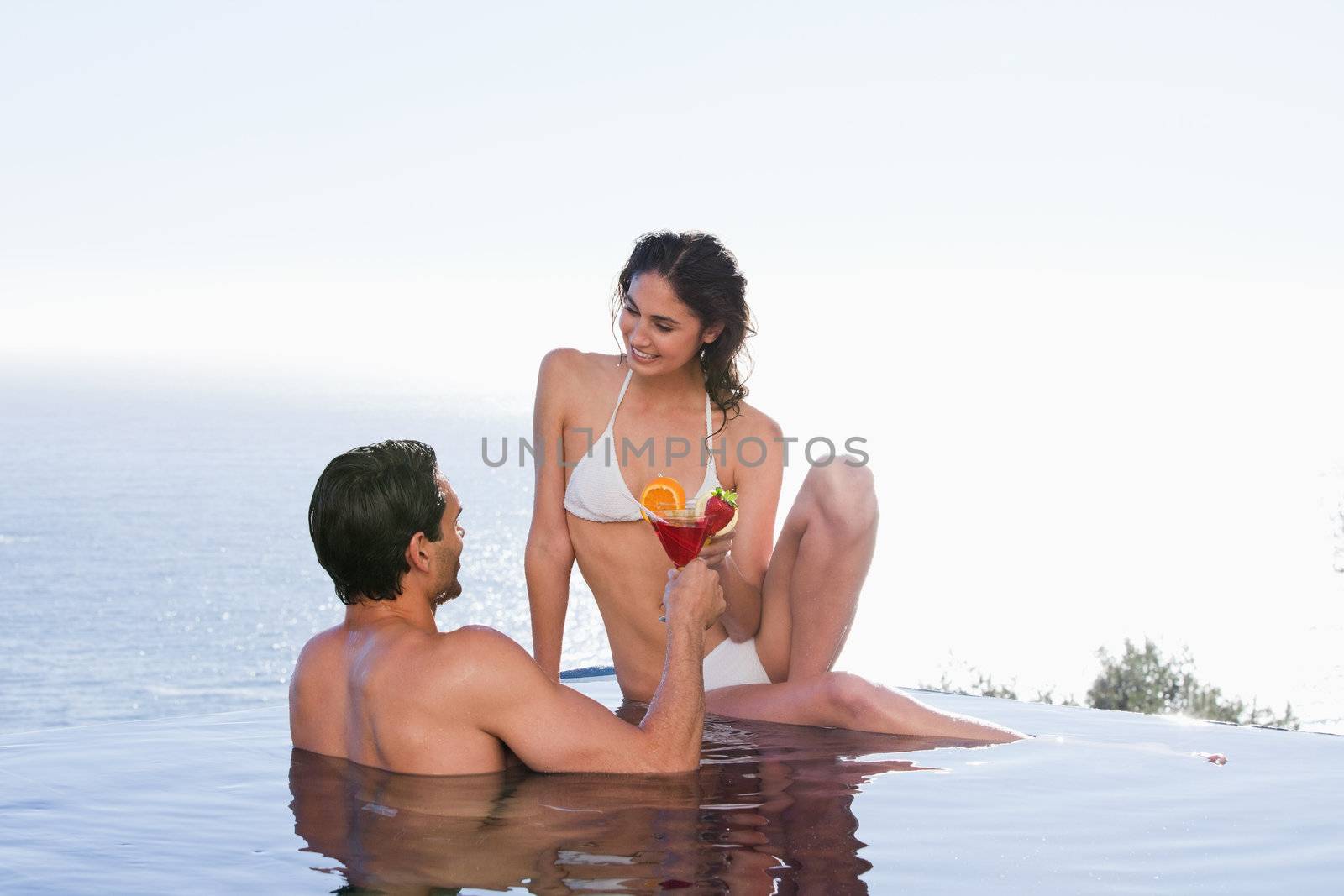 Lovely couple having a cocktail in a swimming pool