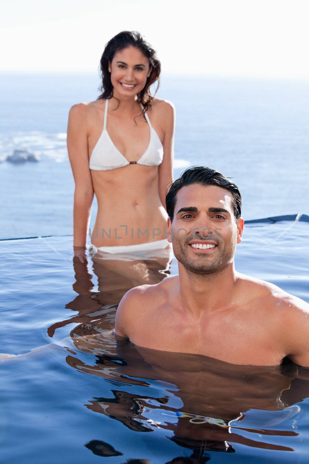 Portrait of a happy couple relaxing in a swimming pool