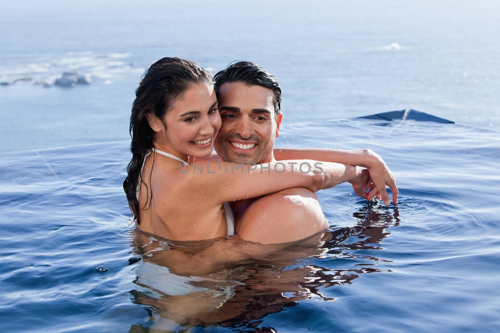 Beautiful couple cuddling each other in a swimming pool