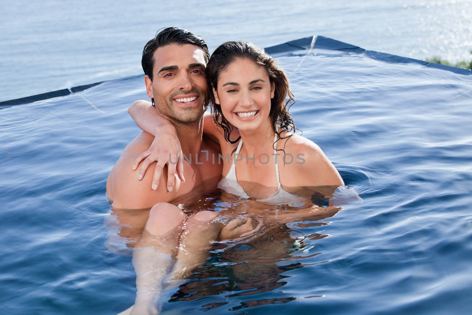 Young couple playing together in a swimming pool