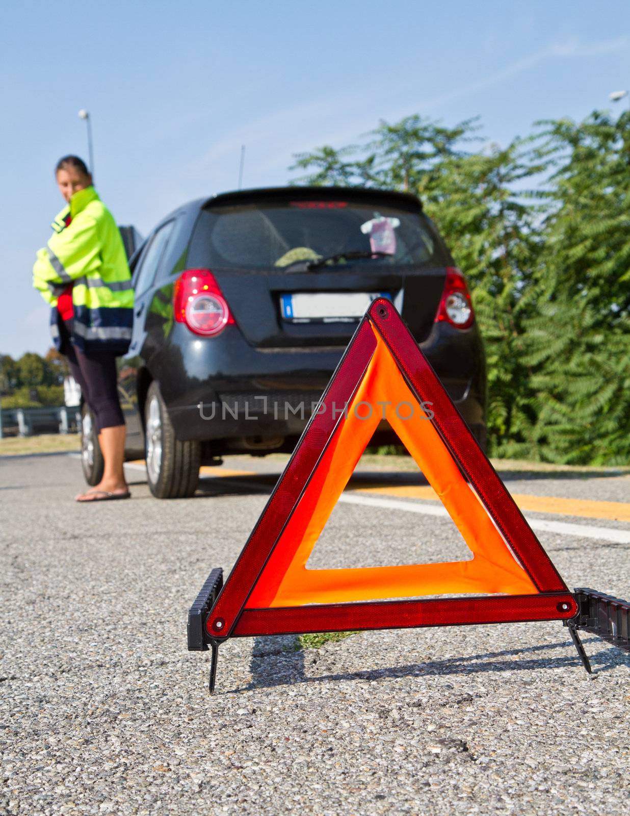 Broken down car with red warning triangle 