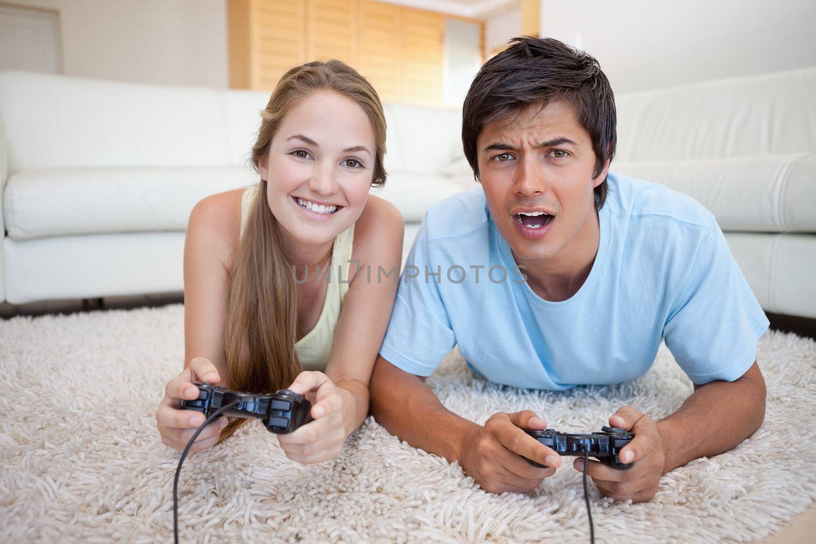 Playful couple playing video games in their living room