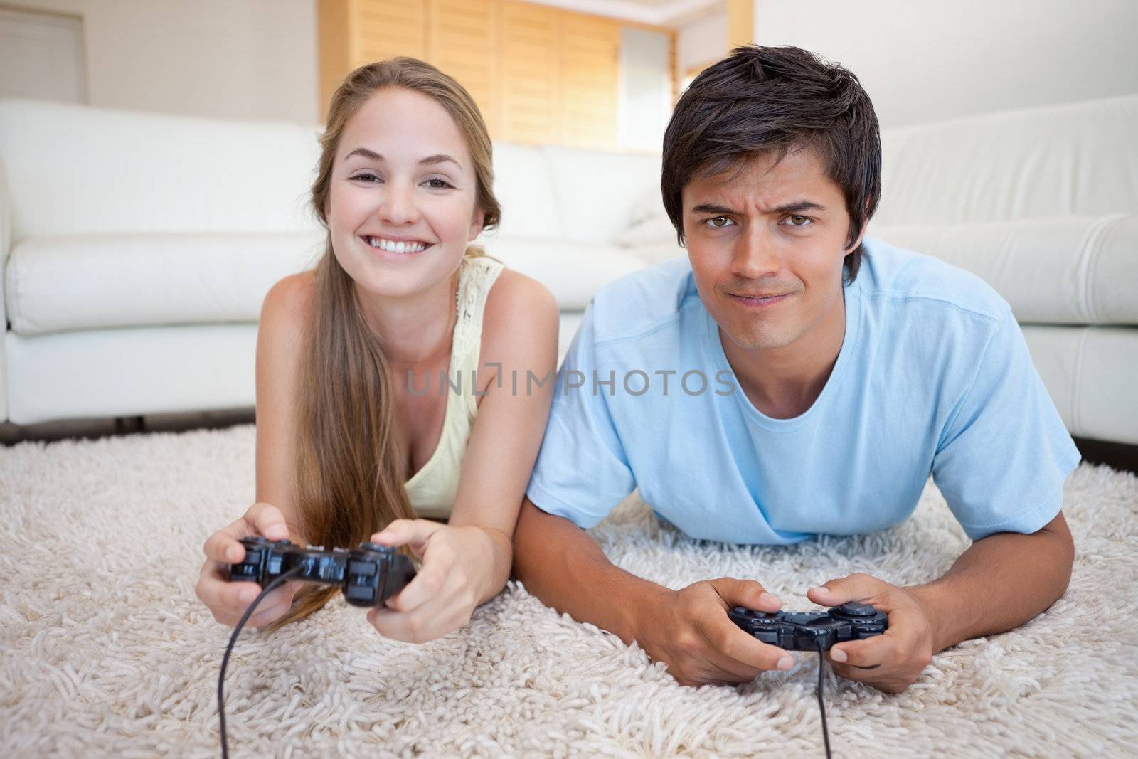 Cheerful couple playing video games in their living room
