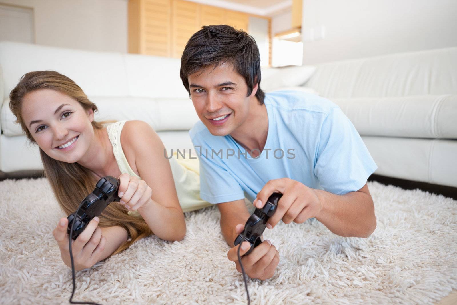 Happy couple playing video games in their living room