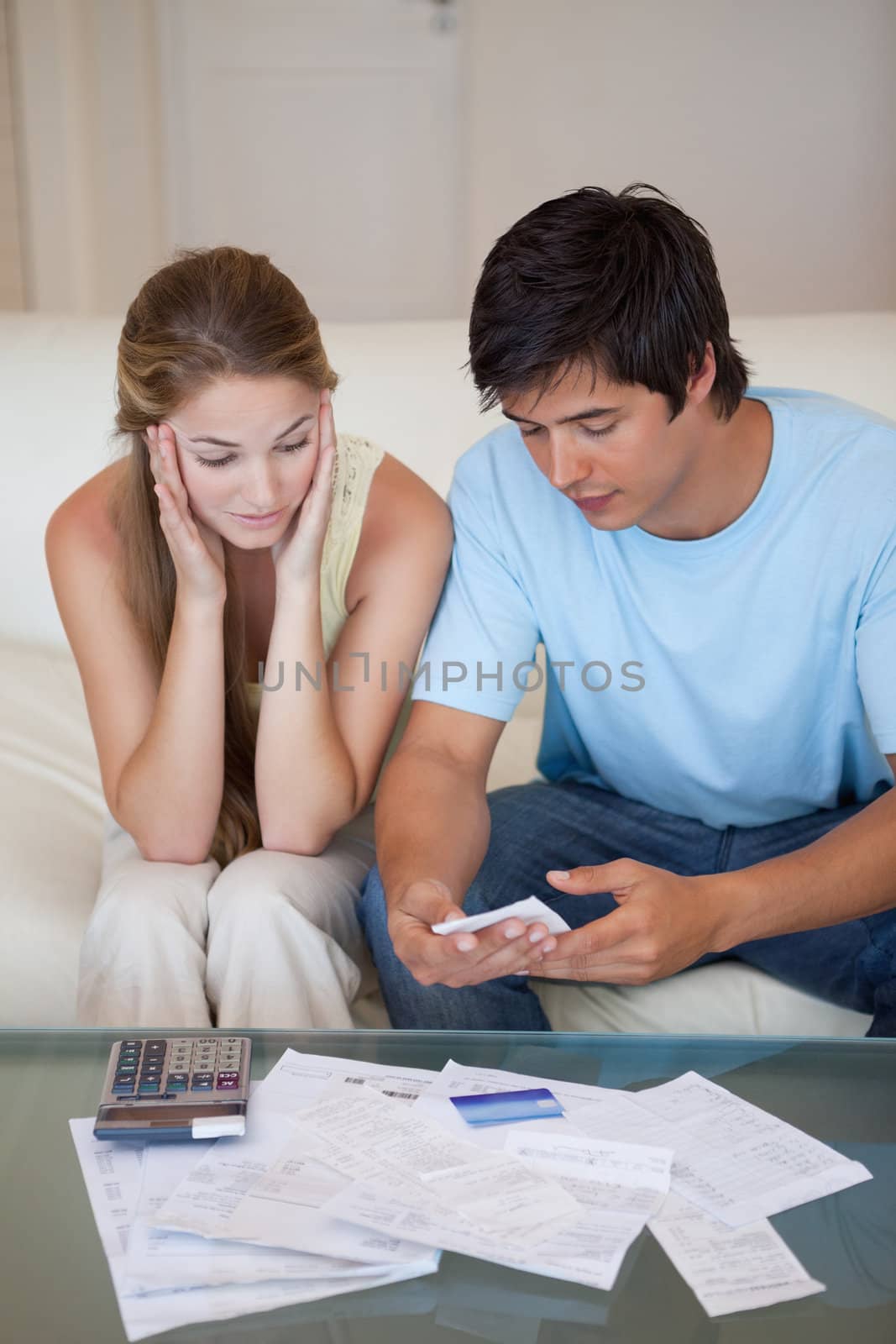 Portrait of a couple looking at their bills in their living room
