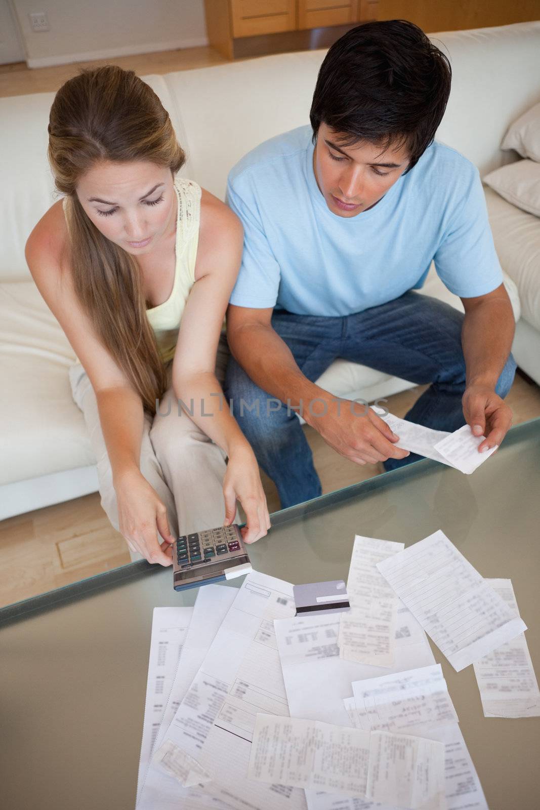 Portrait of a young couple looking at their bills in their living room