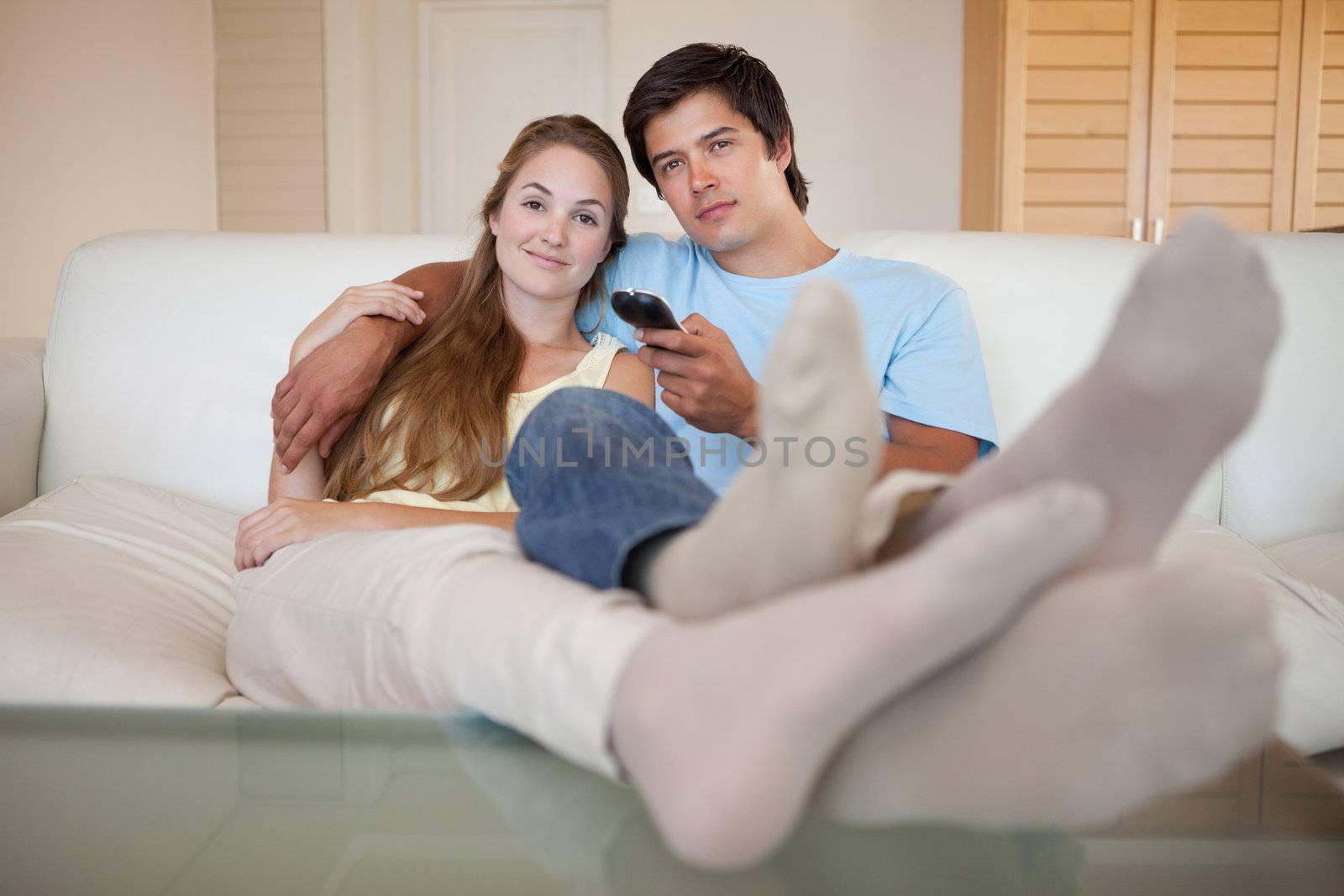 Relaxed couple watching television in their living room