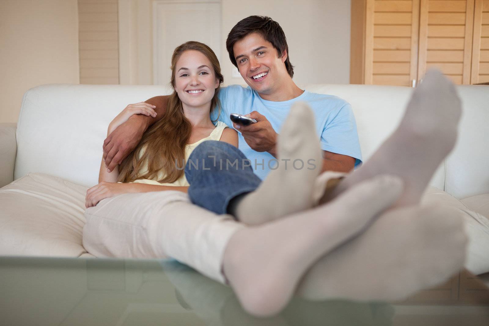 Relaxed young couple watching television in their living room
