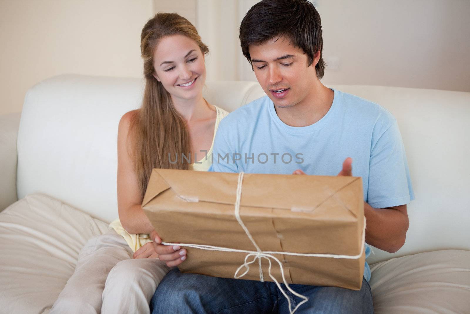 Young couple looking at a package in their living room