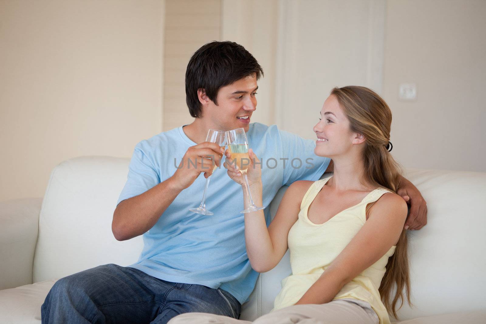 Couple drinking a glass of sparkling wine in their living room