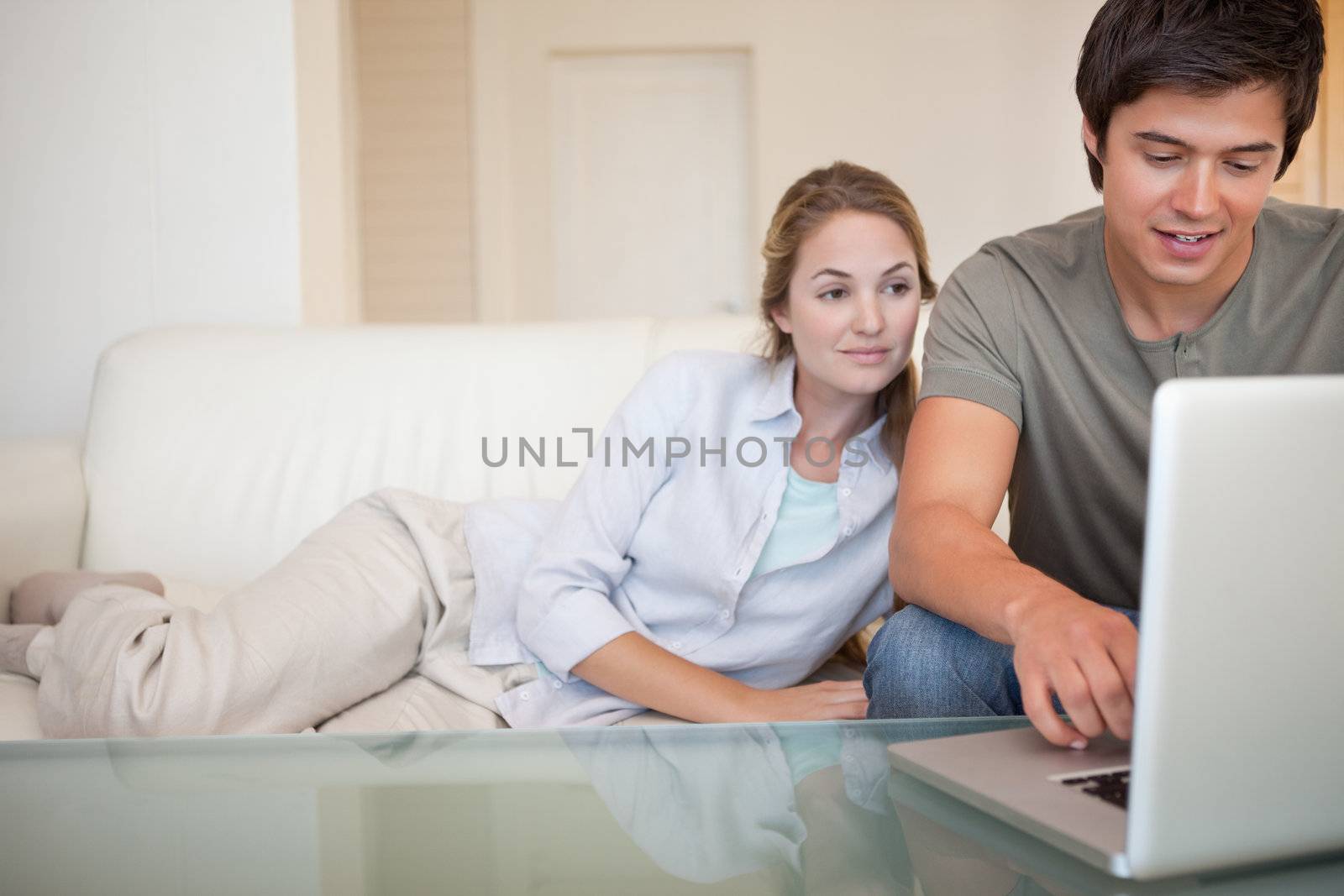 Relaxed couple using a laptop in their living room