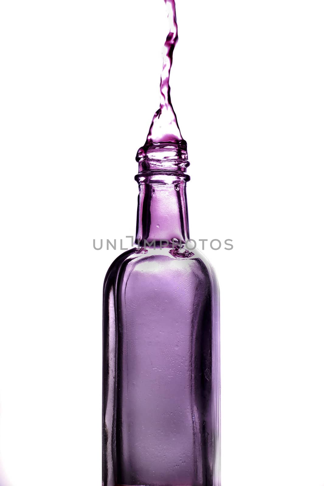 Purple splash from bottle on white background