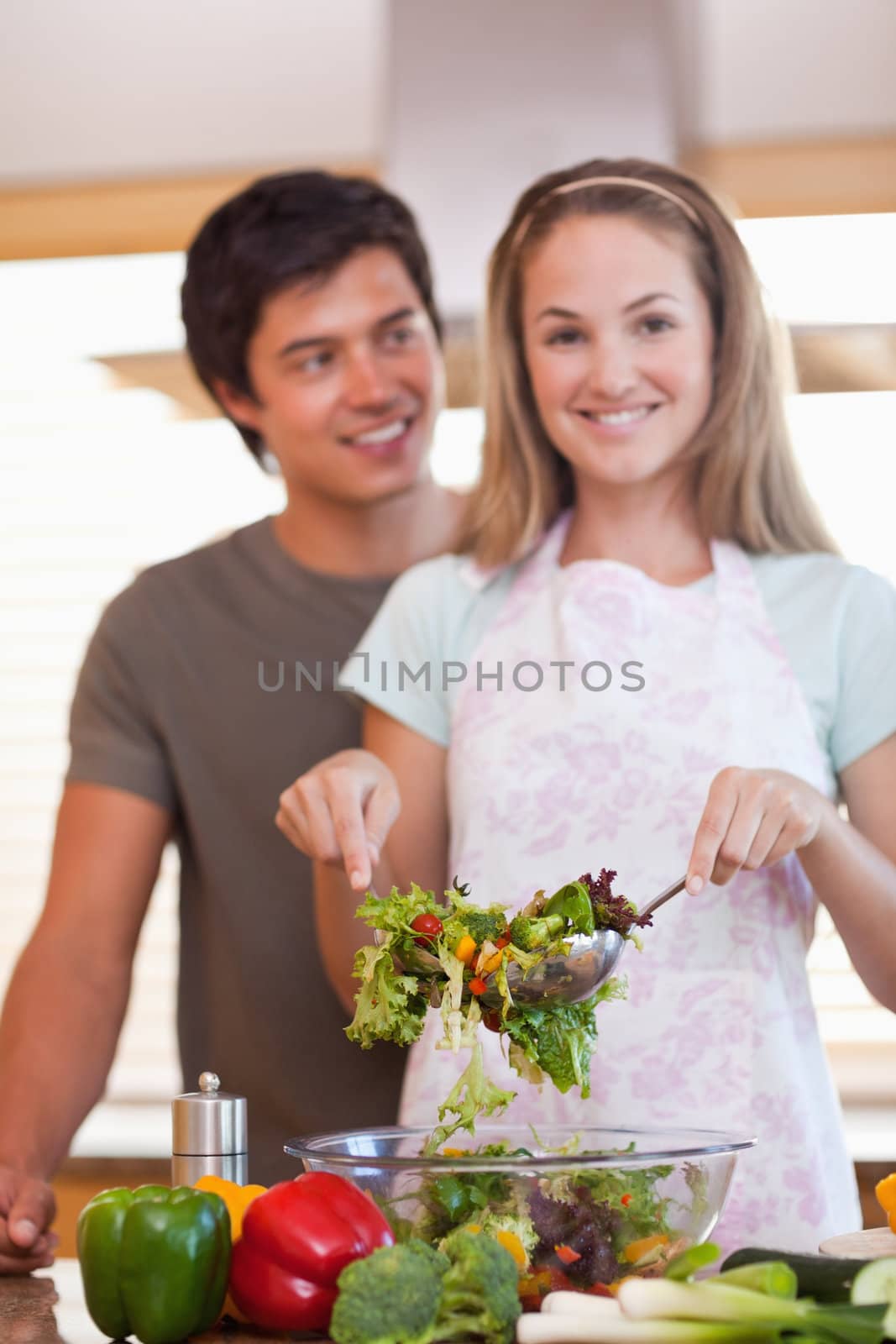 Portrait of a couple making a salad in their kitchen