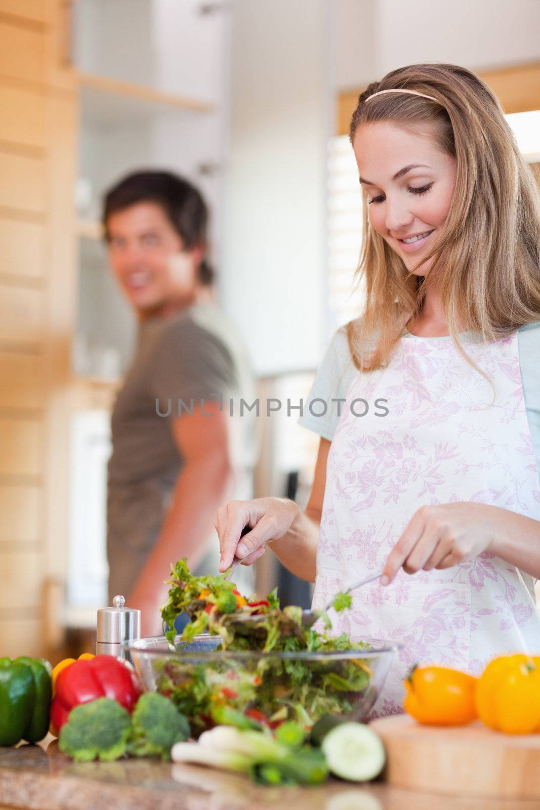 Portrait of a lovely couple making a salad in their kitchen