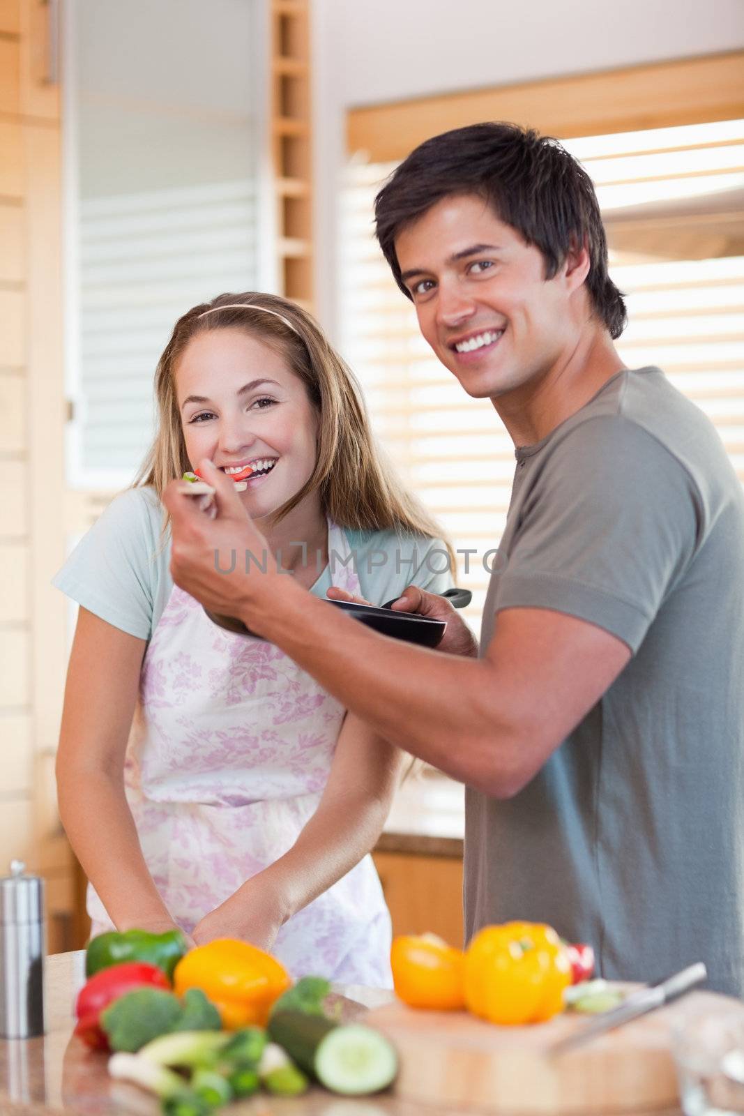 Portrait of a smiling couple preparing dinner in their kitchen