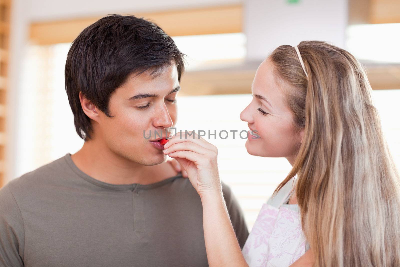 Man tasting the meal of her fiance in their kitchen