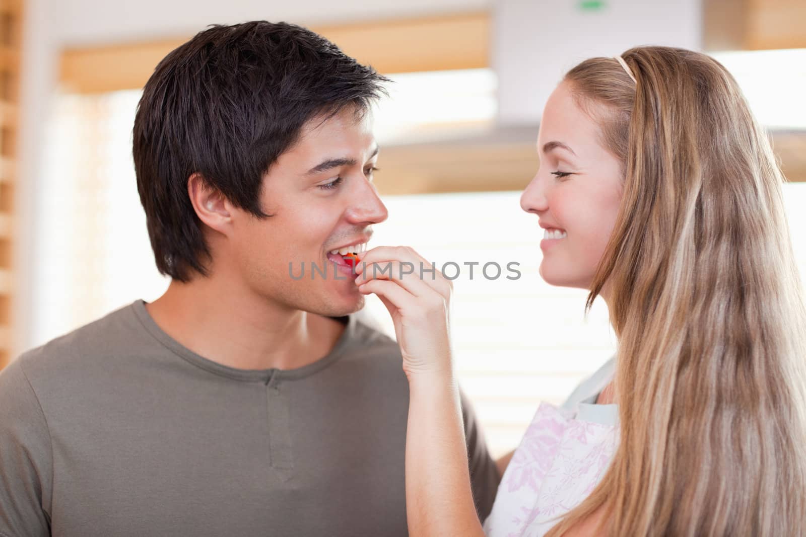 Woman feeding her fiance in their kitchen