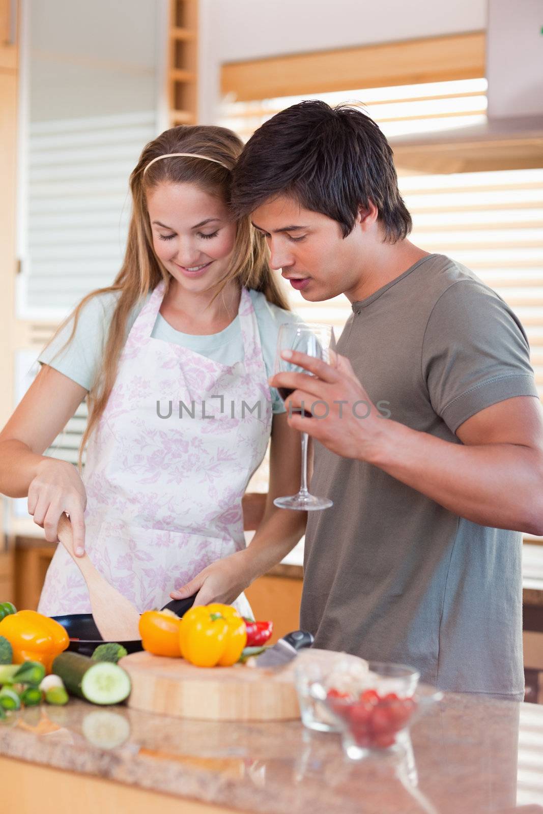 Portrait of a couple cooking while drinking wine in their kitchen