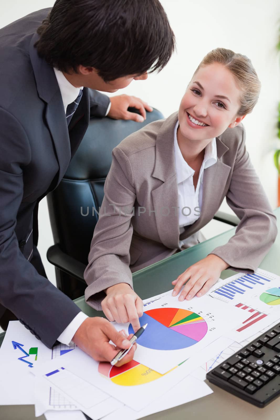 Portrait of a smiling business team studying statistics in a meeting room