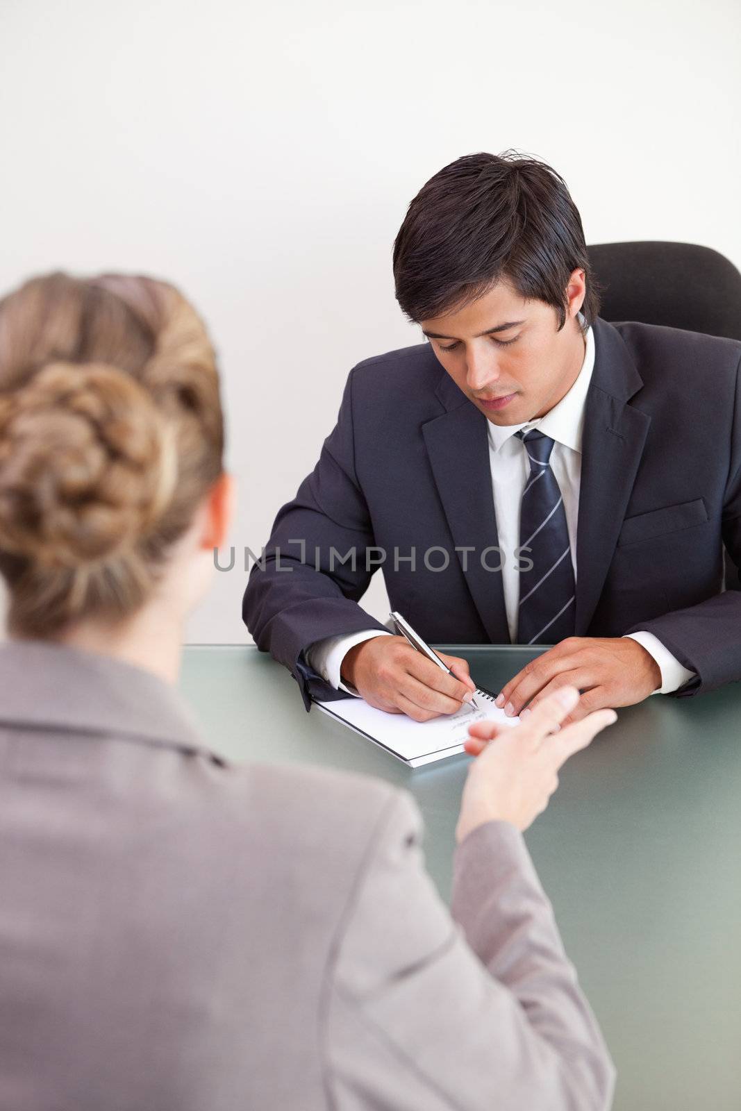 Portrait of a handsome manager interviewing a female applicant in his office