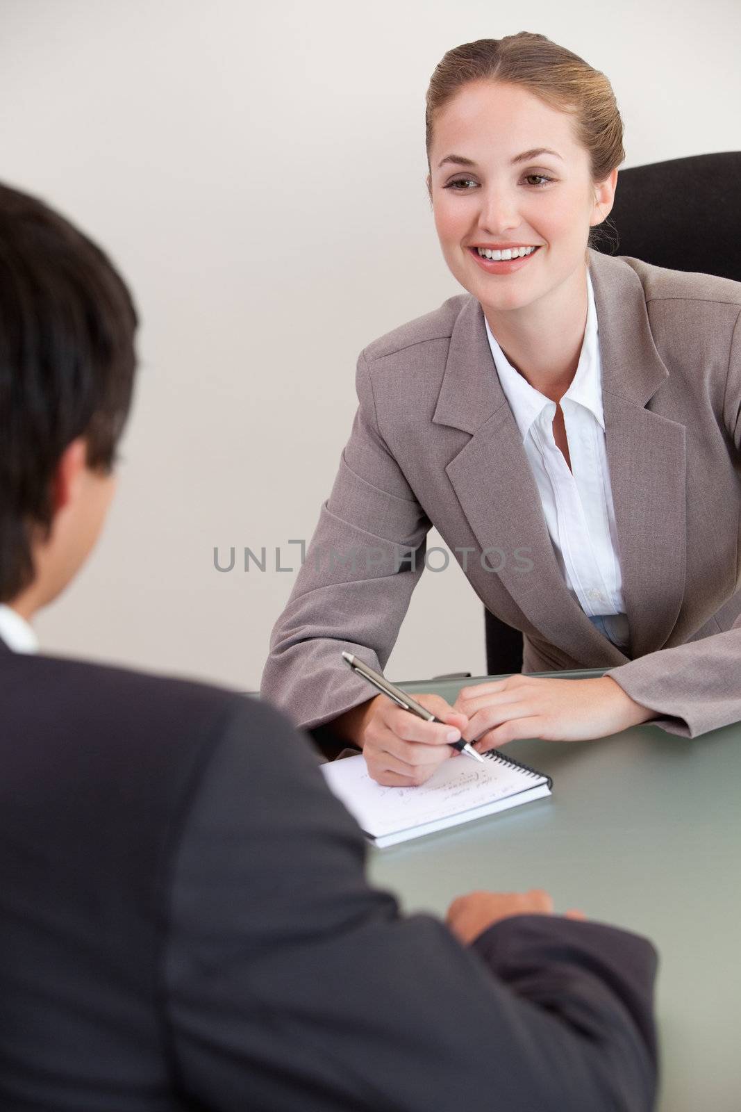 Portrait of a smiling manager interviewing a male applicant in her office