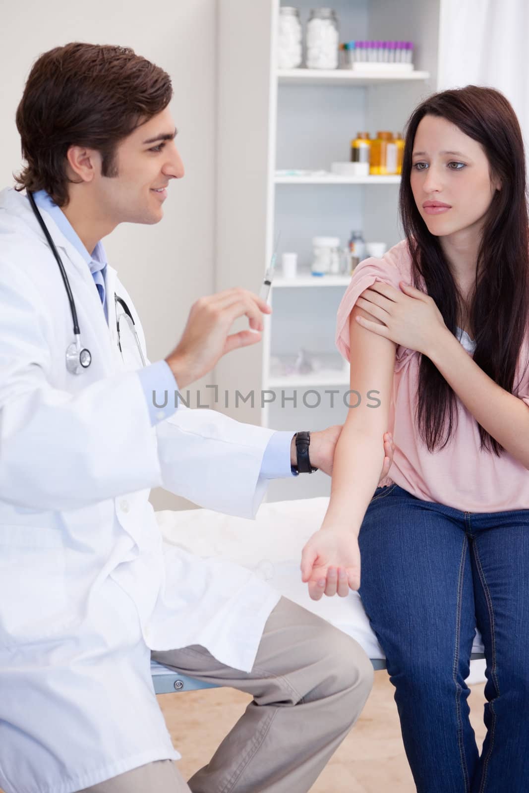 Male doctor about to give an injection to female patient