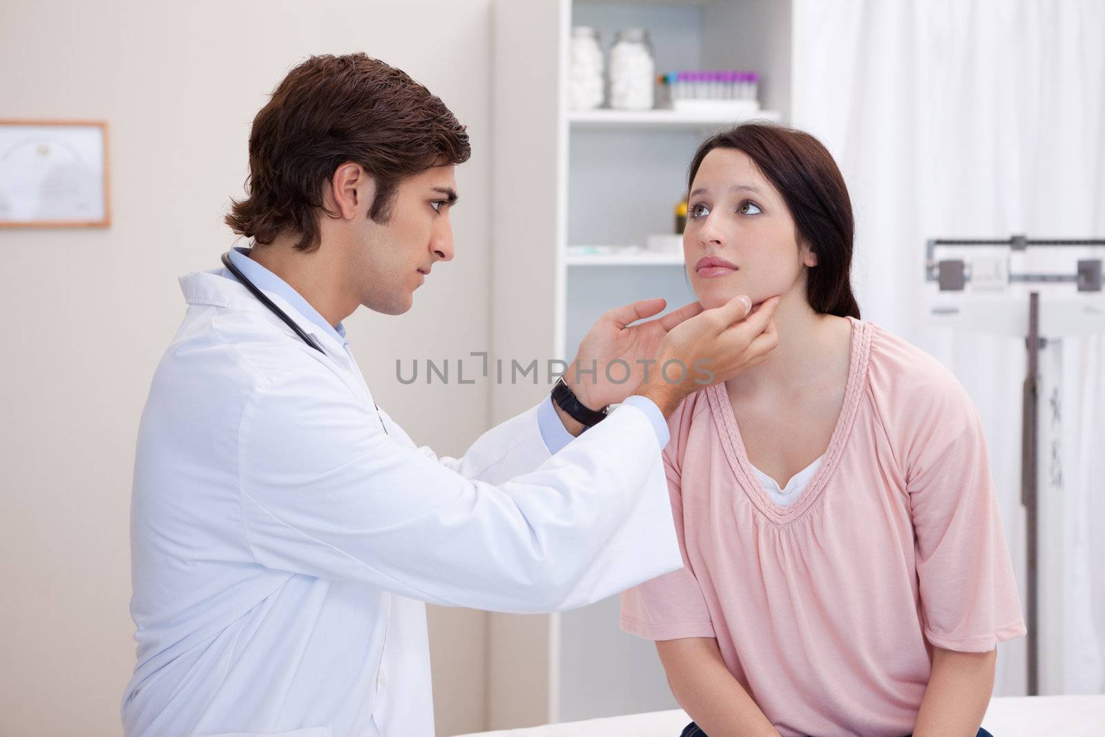 Male doctor examining his patients jaw