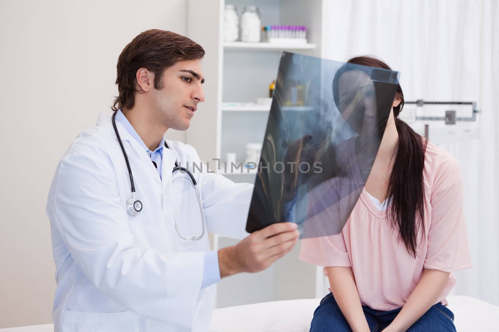 Male doctor analyzing x-ray with his patient
