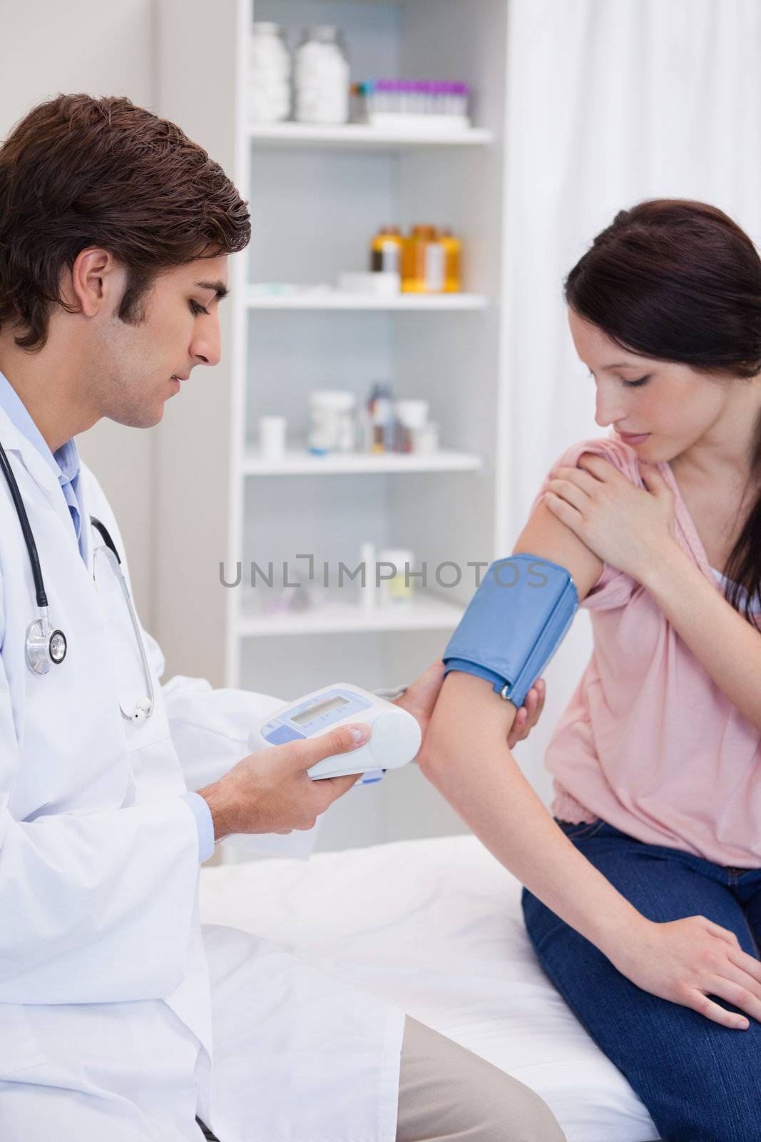 Male doctor analyzing patients blood pressure