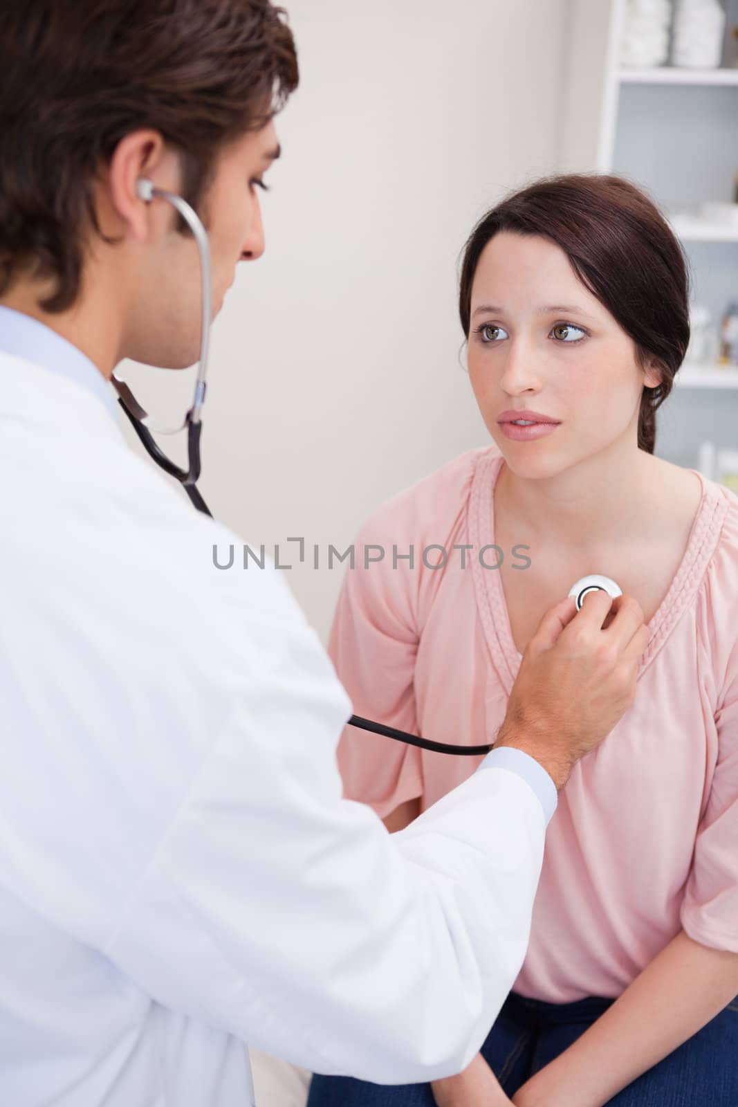 Young doctor taking his patients heart beat