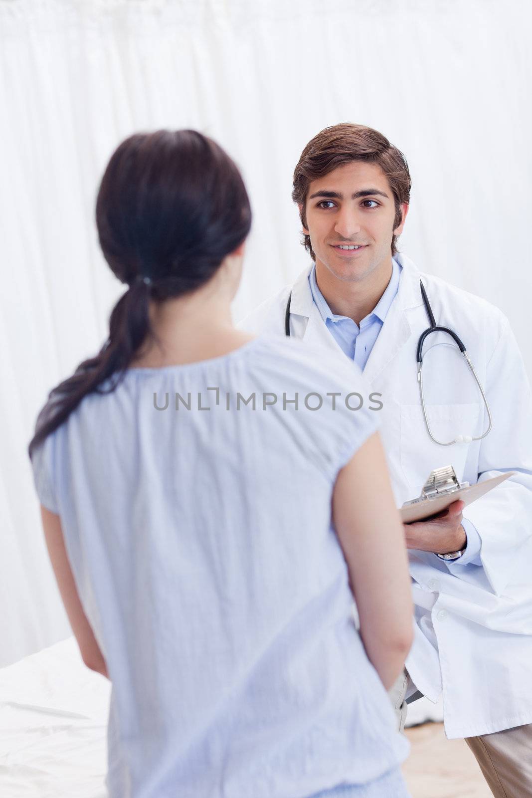Young male physician talking with patient