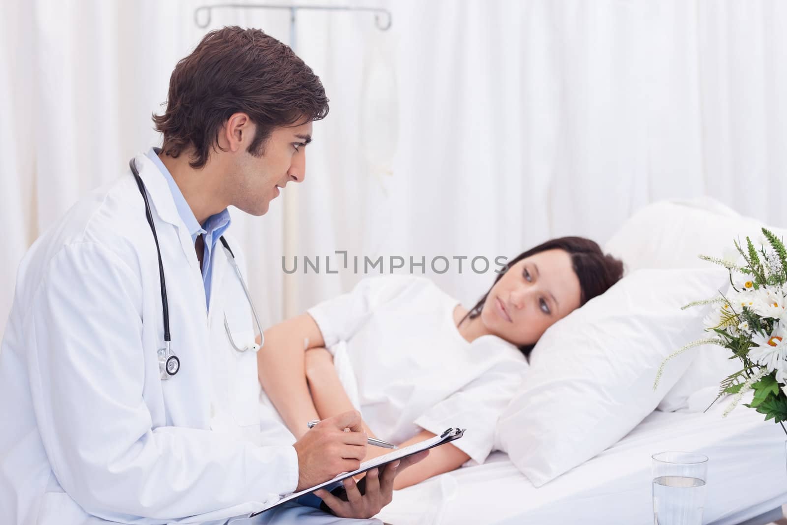Young doctor talking to his patient that just woke up